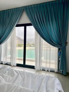 富查伊拉的住宿－Iconic 4-bedroom villa with pool in Fujairah Palm，一间卧室设有大窗户,享有水景