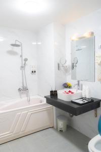 biała łazienka z umywalką i wanną w obiekcie Moon Hotel Cau Giay w mieście Hanoi
