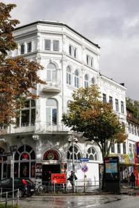 een groot wit gebouw in een stadsstraat bij Sleephotels Casino in Hamburg