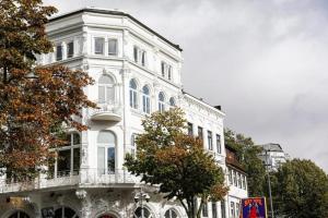 ein weißes Gebäude mit einem Balkon an der Seite in der Unterkunft Sleephotels Casino in Hamburg