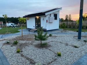 een kleine witte schuur met een grinderf bij Domek Całoroczny Fuleda -Mazury Giżycko Sauna Jacuzii Kominek in Giżycko