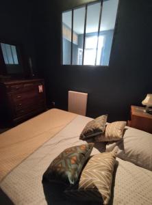 um quarto com uma cama com duas almofadas em Numéro 12, appartement douillet em Montauban