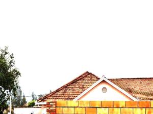 a house with a brick wall and a fence at Room in BB - Martin Aviator Hotel in Kigali