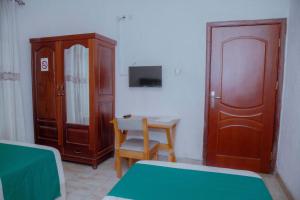 1 dormitorio con mesa, silla y armario en Room in BB - Martin Aviator Hotel en Kigali