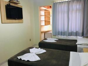 duas camas num quarto de hotel com toalhas em Hotel Paris em Curitibanos