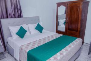 a bedroom with a bed with green and white pillows at Room in BB - Martin Aviator Hotel in Kigali