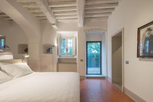 a bedroom with a white bed and a window at Casolese di Vignamaggio in Greve in Chianti