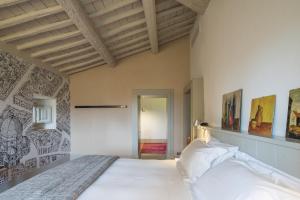 a bedroom with a large white bed in a room at Casolese di Vignamaggio in Greve in Chianti