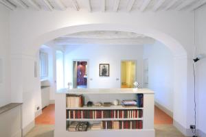 a room with a book shelf filled with books at Casolese di Vignamaggio in Greve in Chianti