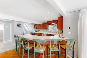 a kitchen with a island with chairs around it at Kingswood Mountainside Retreat in White River Junction
