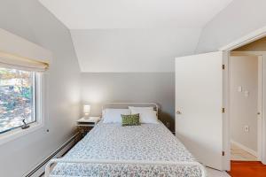 a white bedroom with a bed and a window at Kingswood Mountainside Retreat in White River Junction
