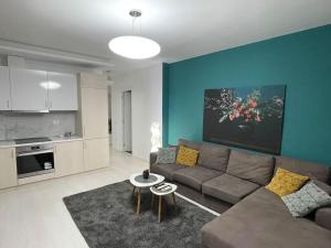 ein Wohnzimmer mit einem Sofa und einer Küche in der Unterkunft Modern Apartment at Train Station in Tirana