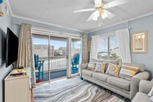 a living room with a couch and a large window at A Place at the Beach 253 in Atlantic Beach