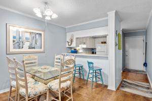 a dining room and kitchen with a table and chairs at A Place at the Beach 253 in Atlantic Beach