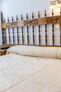 a close up of a bed with a wooden headboard at Hostal Santo Domingo de Silos in Santo Domingo de Silos