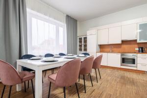 - une cuisine avec une table et des chaises blanches dans l'établissement Old Town - Vaike Karja Apartment, à Tallinn