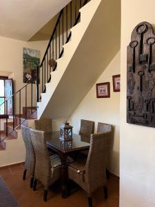 een eetkamer met een tafel en stoelen en een trap bij Casa Rural "El Carrasca" in El Carrascalejo
