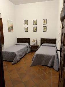 2 letti posti uno accanto all'altro in una camera da letto di Casa Rural "El Carrasca" a El Carrascalejo