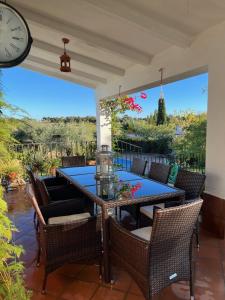 een patio met een tafel en stoelen en een klok bij Casa Rural "El Carrasca" in El Carrascalejo