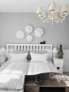 a bedroom with a white bed and a chandelier at Das Ruebezahl in Reit im Winkl