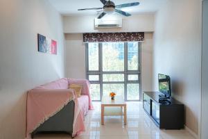 ein Wohnzimmer mit einem rosa Stuhl und einem Fenster in der Unterkunft GT2@Cascades Residency in Petaling Jaya