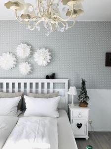 a bedroom with a white bed and a chandelier at Das Ruebezahl in Reit im Winkl