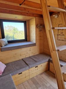 um pequeno quarto num chalé de madeira com uma janela em Location Tiny House Loule em Loulé