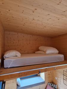 two beds in a room with a wooden ceiling at Location Tiny House Loule in Loulé