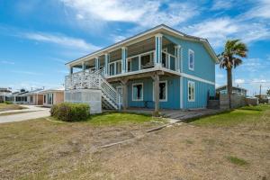 een blauw huis met een palmboom ervoor bij Best - Little - Orr House in Rockport