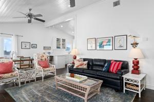 een woonkamer met een zwarte bank en stoelen bij Best - Little - Orr House in Rockport