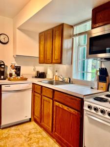 a kitchen with wooden cabinets and a white stove top oven at Across The INN Entire 3 bedr Colonial House with lovely porch & extremely fast Wi-Fi in Washington, Virginia