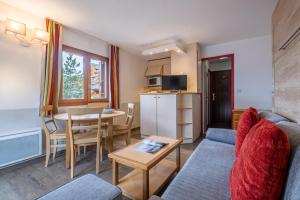a living room with a couch and a table at R&eacute;sidence Pierre & Vacances Les Ravines in M&eacute;ribel