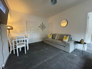 una sala de estar con un sofá y una mesa en Cardonald House, en Glasgow