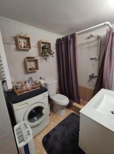 a bathroom with a toilet and a washing machine at Little heaven in Alimos/Athens! in Athens