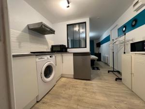 a laundry room with a washing machine and a sink at La Pause - studio en ville in Cherbourg en Cotentin