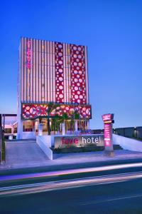 un grand hôtel avec un panneau de motel devant lui dans l'établissement favehotel Rembang, à Rembang