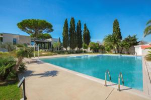 een groot zwembad met bomen op de achtergrond bij Villa Ottavia by Perle di Puglia in Porto Cesareo