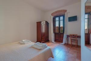 a bedroom with a bed and a table with a chair at La Scala del Sale in Iglesias