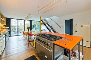 cocina con encimera de naranja y fogones en Veeve - The Artist's House en Londres