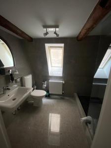 a bathroom with a sink and a toilet and a window at Apartment Klara in Lübeck