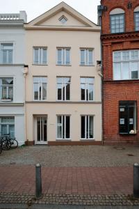 un gran edificio blanco junto a un edificio de ladrillo en Apartment Klara, en Lübeck