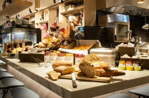 a bakery counter with bread and other items on it at Hotel Indigo Antwerp City Centre, an IHG Hotel in Antwerp