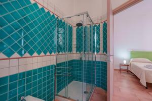 Łazienka z prysznicem wyłożona jest zielonymi kafelkami. w obiekcie La Scala del Sale w mieście Iglesias