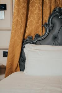 een bed met een zwart hoofdeinde en een wit kussen bij Emotional Grand Motel in Fontaneto dʼAgogna