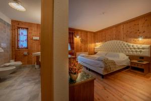 a bedroom with a bed and a bath room at Hotel Lo Scoiattolo in Gressoney-la-Trinité