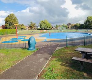 a park with a swimming pool with a picnic table at Wilton Retreat in Southampton