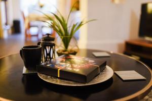 a book on a table with a cup and a coffee mug at Beautiful Large 4 Bedrooms house in central Southampton in Southampton