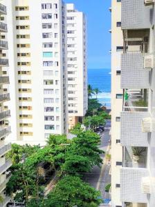 an aerial view of two tall buildings and the ocean at Pé na Areia a Poucos Metros -Apartamento Guarujá Pitangueiras in Guarujá