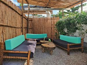a patio with two beds and a table at Hakuna Matata Boutique in Paje