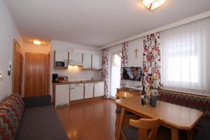 cocina y sala de estar con mesa en una habitación en Bella Vista Active Apart, en Nauders